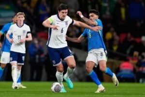 Duel Harry Maguire dan Lucas Paqueta dalam laga persahabatan antara Inggris vs Brasil, Minggu (24/3/2024) dini hari WIB